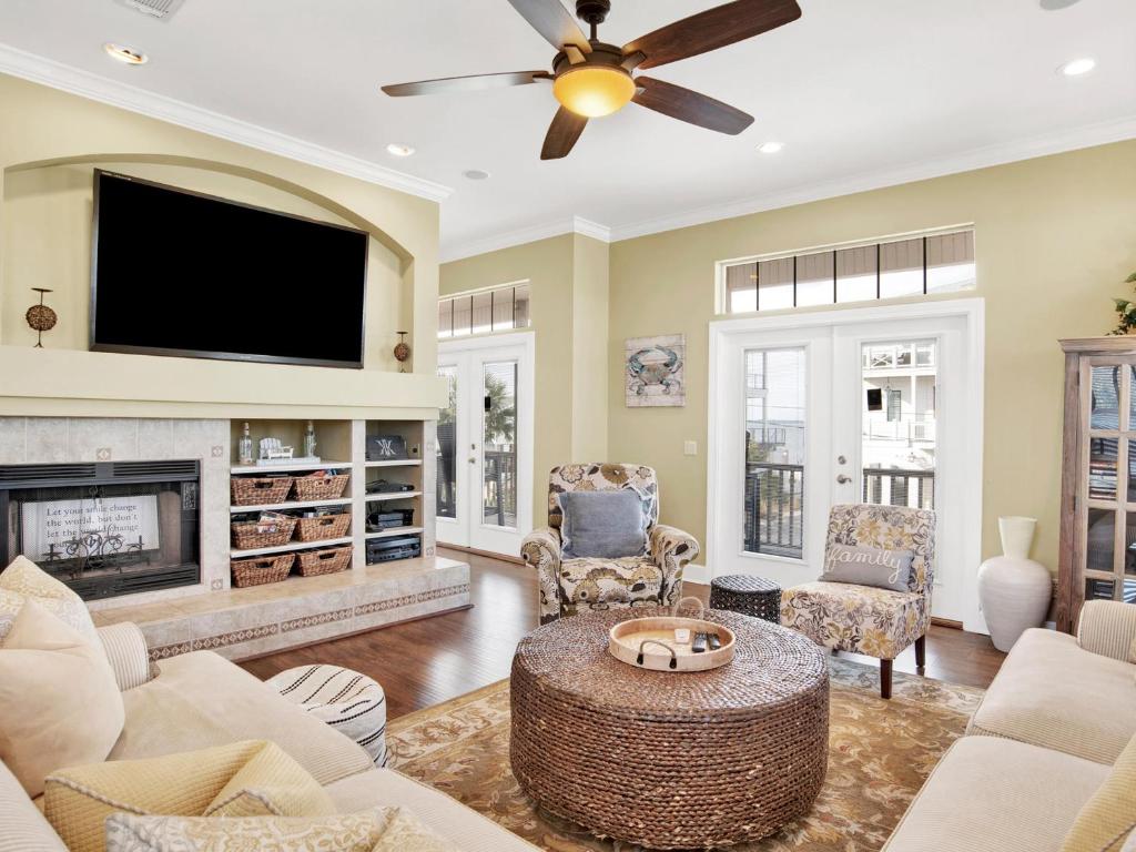 a living room with a fireplace and a flat screen tv at Playa Panferio in Pensacola Beach
