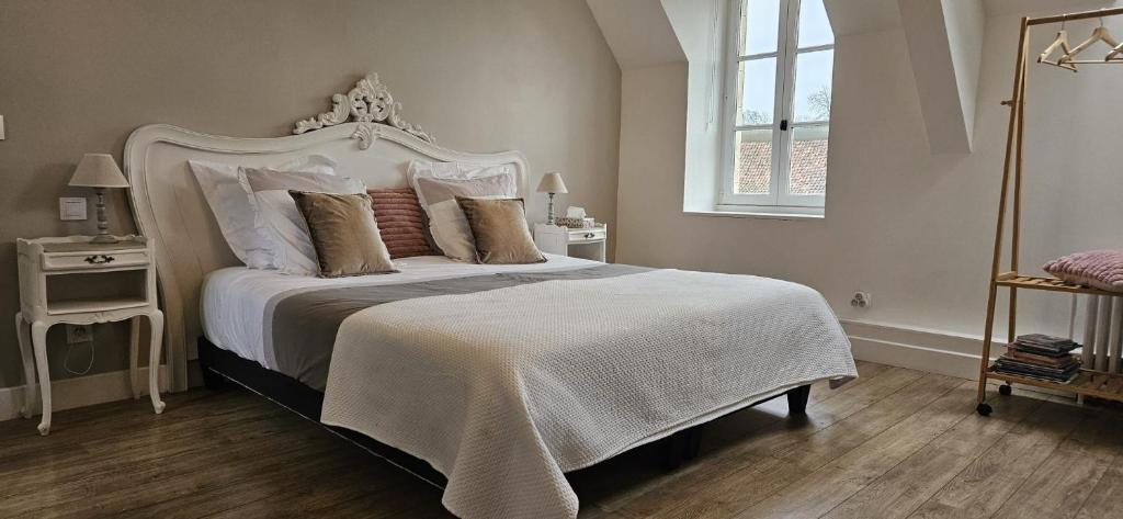 a bedroom with a large white bed with pillows at Petit manoir de la berthenlaire in Baincthun