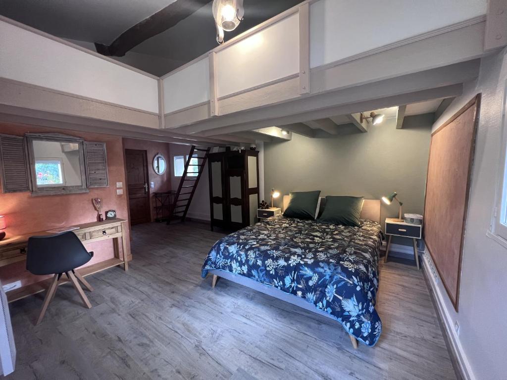 1 dormitorio con cama, escritorio y escalera en Bienvenue Chez Vous en Émancé
