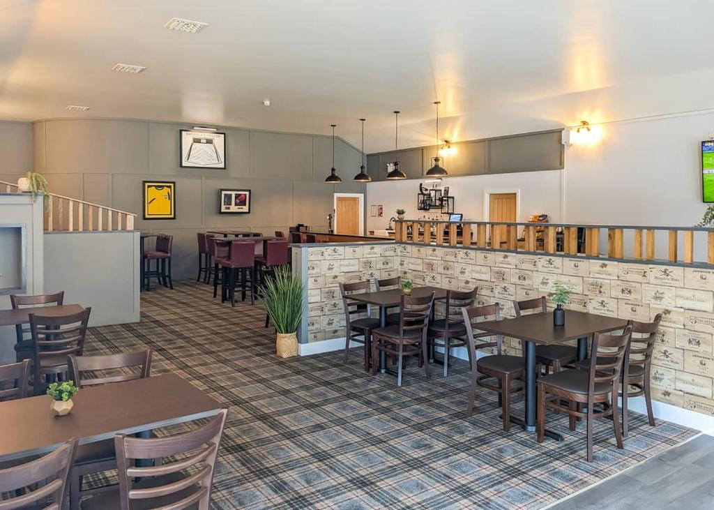 a restaurant with tables and chairs and a bar at The Warrens At Foxtail in Chirk