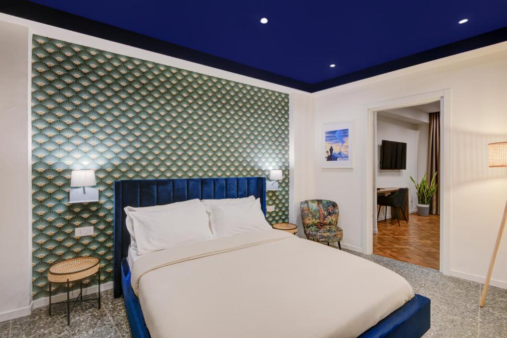 una camera con letto e soffitto blu di Well Suites - Piazza dei Martiri a Napoli