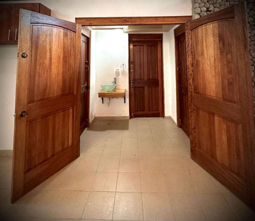 un couloir vide avec deux portes en bois et un lavabo dans l'établissement Blasina el valle, à El Valle de Antón