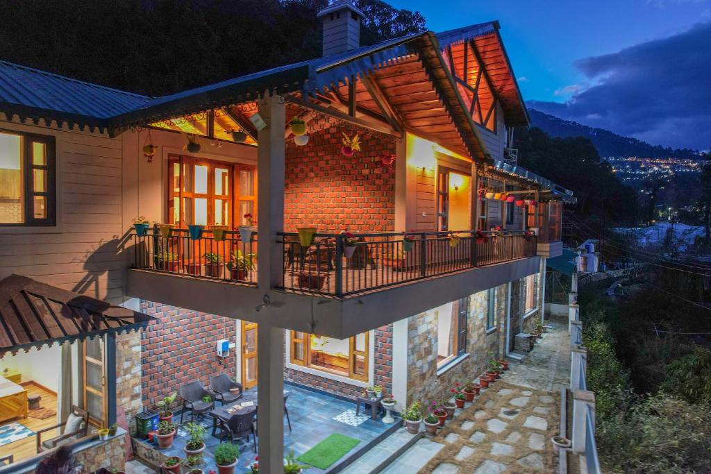 an aerial view of a house with a balcony at SaffronStays Wood Sparrow - 2BR Pet-Friendly Lakeside & Hill View Cottage for Families in Bhīm Tāl