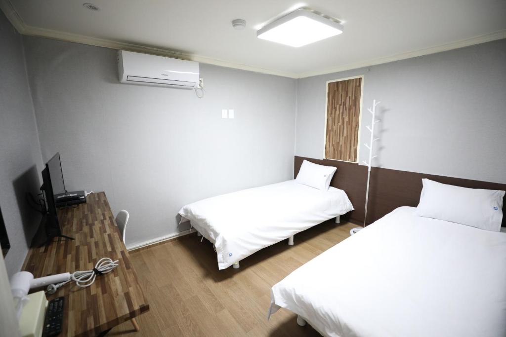 a hotel room with two beds and a television at Hotel Golden Hill in Seoul