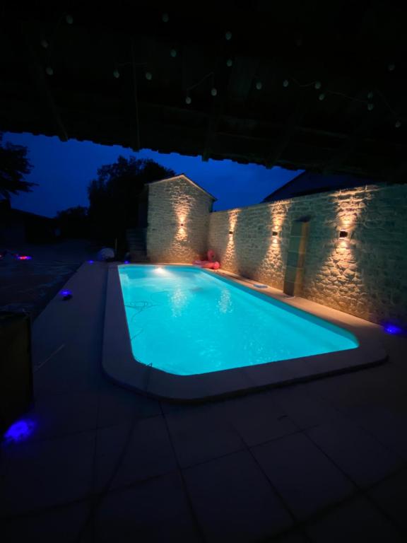 una piscina iluminada por la noche con luces en Gite Provençal du Mas Arnaud en Arlés