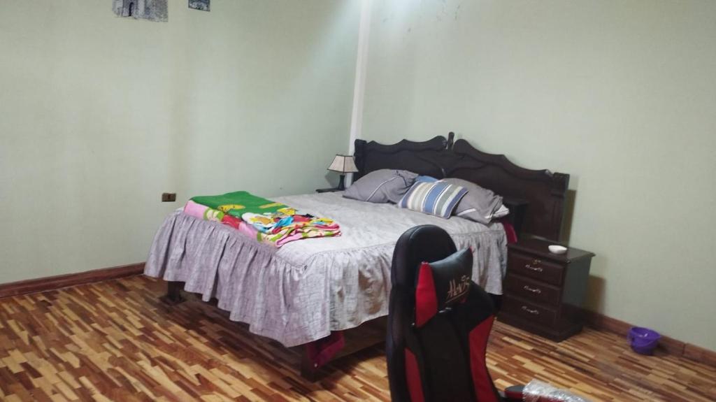 um quarto com uma cama e piso em madeira em Habitación Matrimonial Oruro Carnaval em Oruro