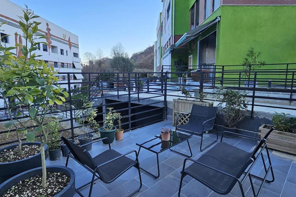 un ensemble de chaises et de tables sur un balcon dans l'établissement Deluxe Flat with garden_Tirana, à Tirana