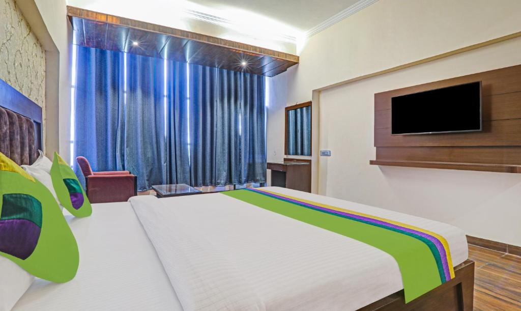 a bedroom with a large bed with a tv on the wall at Hotel The Golden Bird in Agra