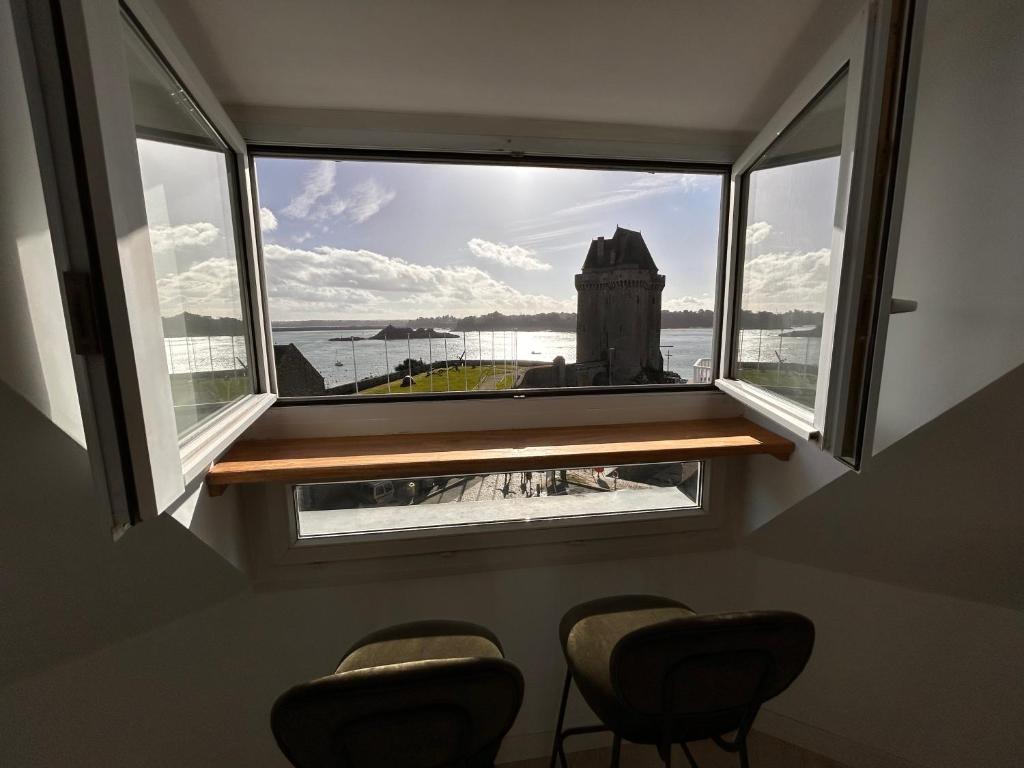 - une fenêtre avec trois chaises dans une chambre avec vue dans l'établissement Rance Solidor, à Saint-Malo