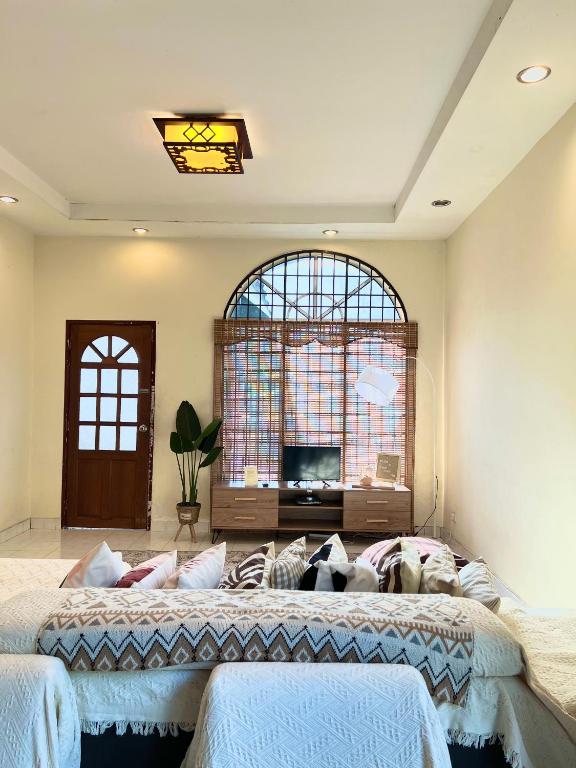a bedroom with two beds and a large window at RUMAH SANTAI in Sungai Petani