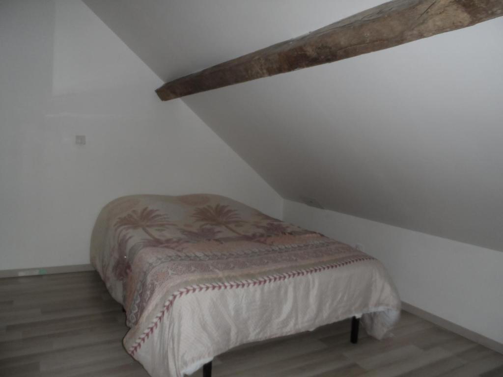 a bedroom with a bed in the corner of a attic at La casa en el campo A 20 minutes de Zoo Beauval &amp; 8 minutes de la flamme olympique à Valençay in Vicq-sur-Nahon