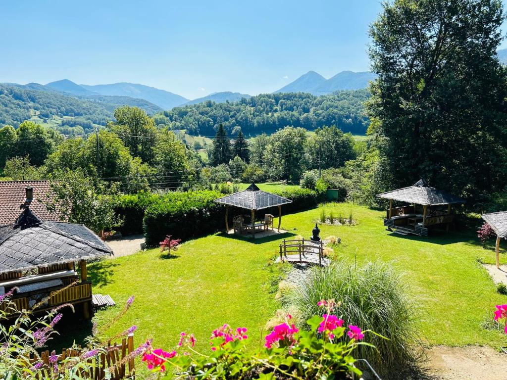 een tuin met tafels, tuinhuisjes en bloemen bij Camping-Gites Au songe du Valier in Seix