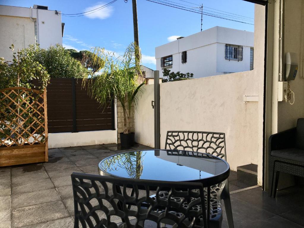 een tafel en stoelen op een patio bij Plage à 400 m Studio tout confort Terrasse Clim Parking in Hyères