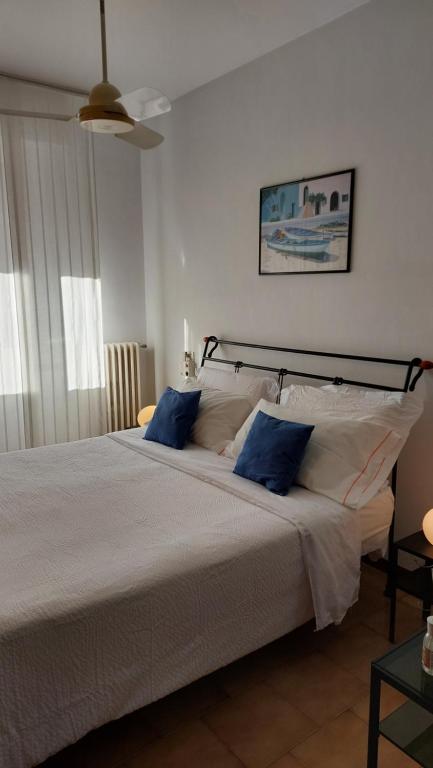 a bedroom with a large bed with blue pillows at Antonia's Guest House in Rimini