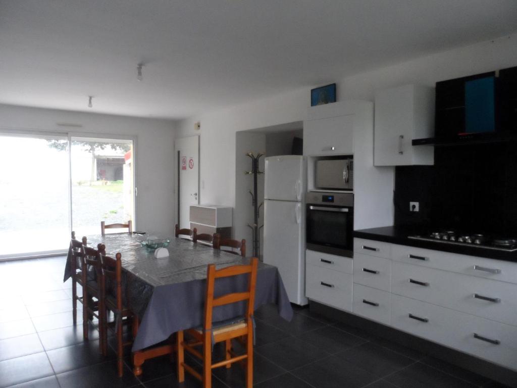 a kitchen with a table with chairs and a refrigerator at La casa en el campo A 20 minutes de Zoo Beauval &amp; 8 minutes de la flamme olympique à Valençay in Vicq-sur-Nahon