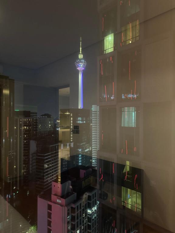 uma vista para a torre de tokyo na cidade à noite em Soho Suites KLCC By Inam Suites em Kuala Lumpur