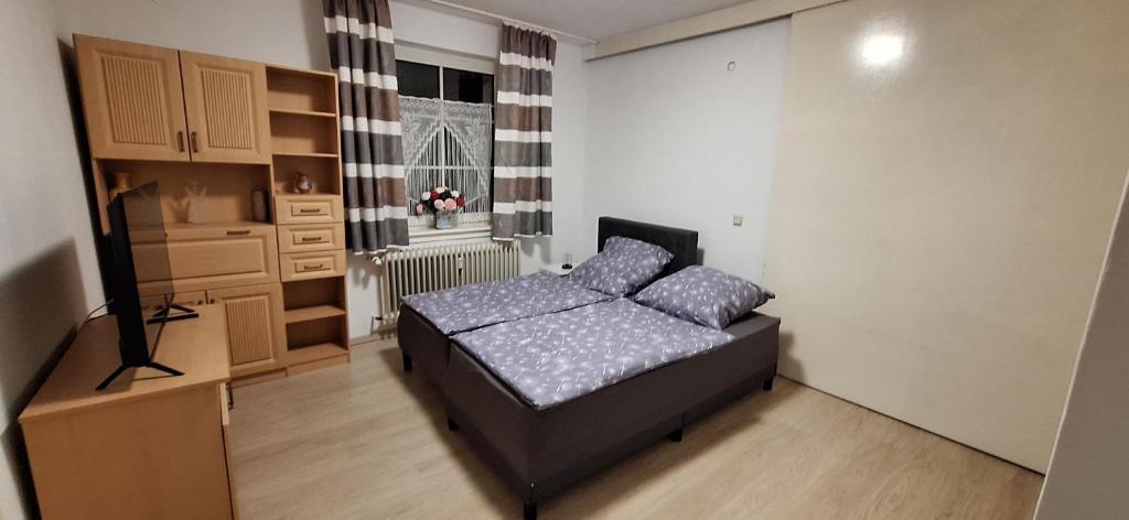 a small bedroom with a bed in a room with a window at Gartenblick in Kirchhain