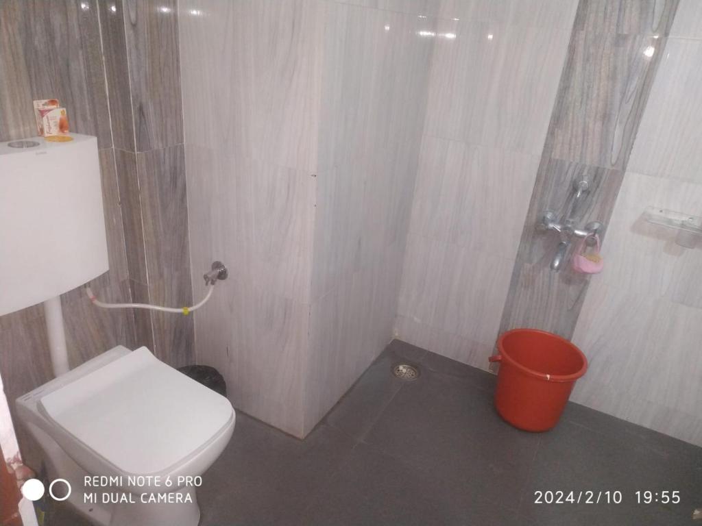 a small bathroom with a toilet and a bucket at Leela Homestay Indore - Orchid - One Bedroom with Hall and balcony in Indore