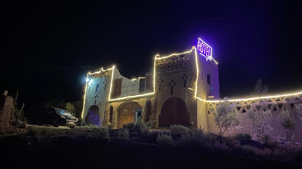un edificio con luces encendidas por la noche en Auberge Palacio Sidi Hamza, en Tazrouft