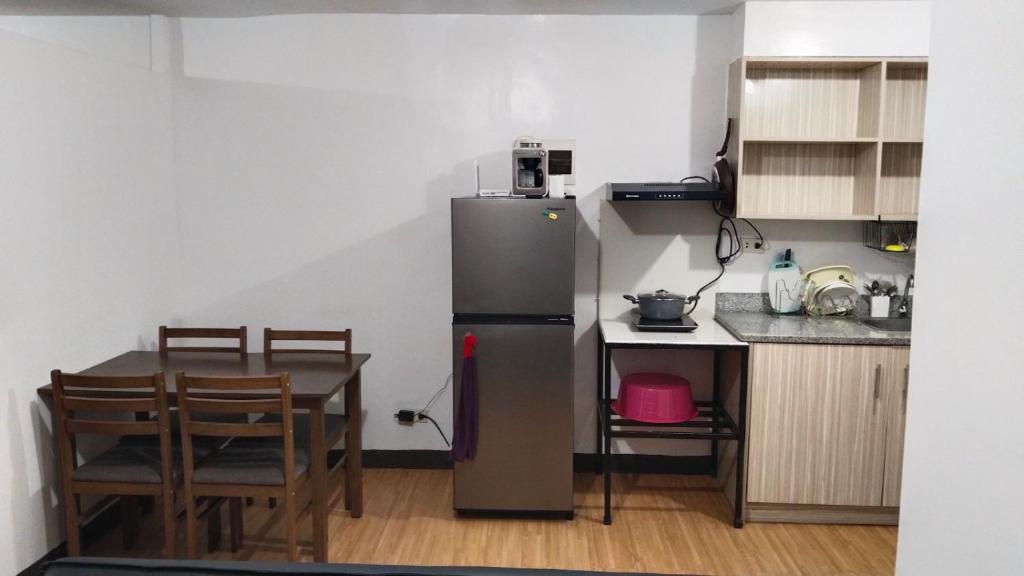 een kleine keuken met een tafel en een koelkast bij ALLEJA CONDOMINIUM in Imus