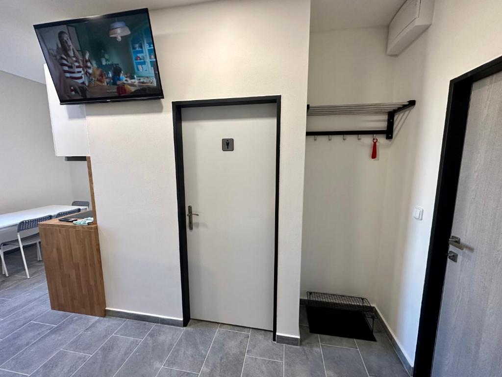 a room with a white door and a tv on the wall at Hotel Hangar in Mošnov