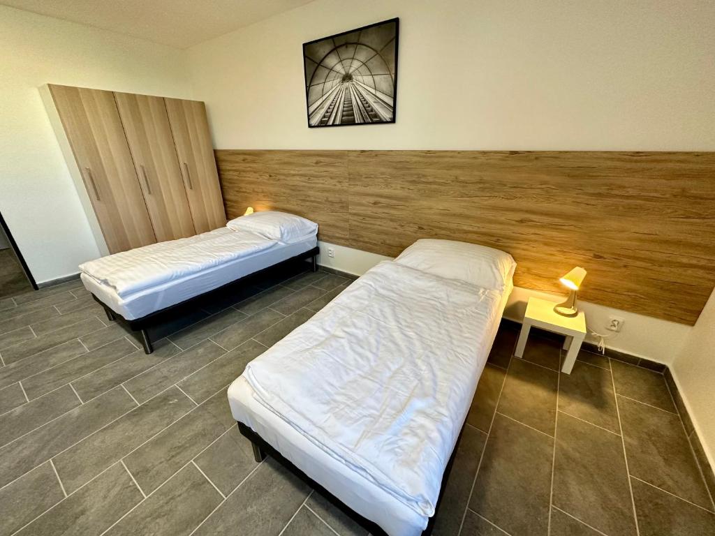 a room with two beds and a table with a lamp at Hotel Hangar in Mošnov