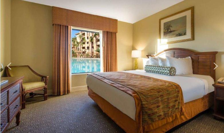 a hotel room with a large bed and a window at Tahiti Village in Las Vegas