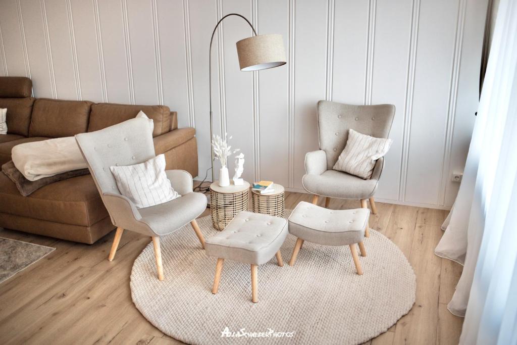 Wipfeld的住宿－Mainblick Apartment，客厅配有两把椅子和一张沙发