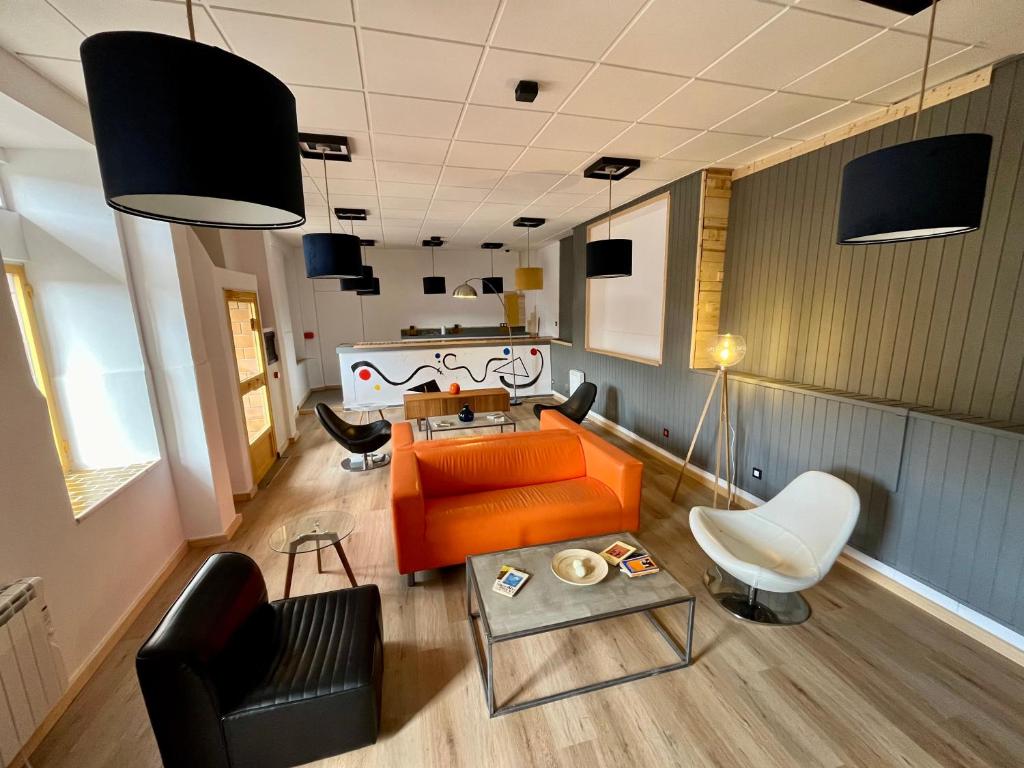 - un salon avec un canapé et des chaises orange dans l'établissement The Orange Teddy Bear Hostal La Peña, à Mieres