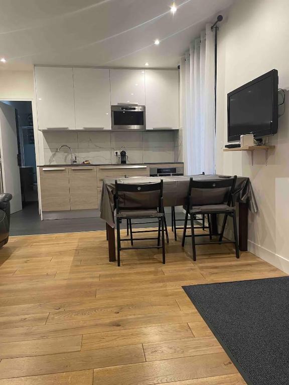 une cuisine et une salle à manger avec une table et des chaises dans l'établissement Maison de ville, à Vitry-sur-Seine