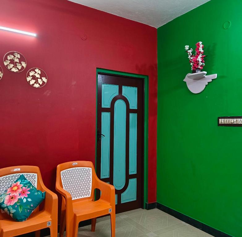 two chairs in a room with green and red walls at Blue Waves HomeStay in Pondicherry