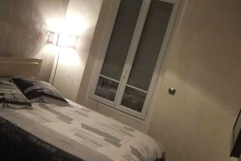 a bedroom with a bed and a window at APPARTEMENT PORTE CHAMPERRET in Levallois-Perret