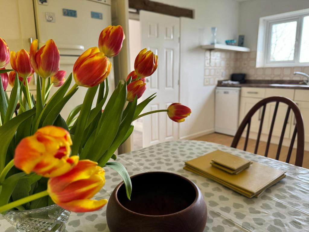un vase de fleurs sur une table dans une cuisine dans l'établissement Mulberry Lawn Apartments, à Brading