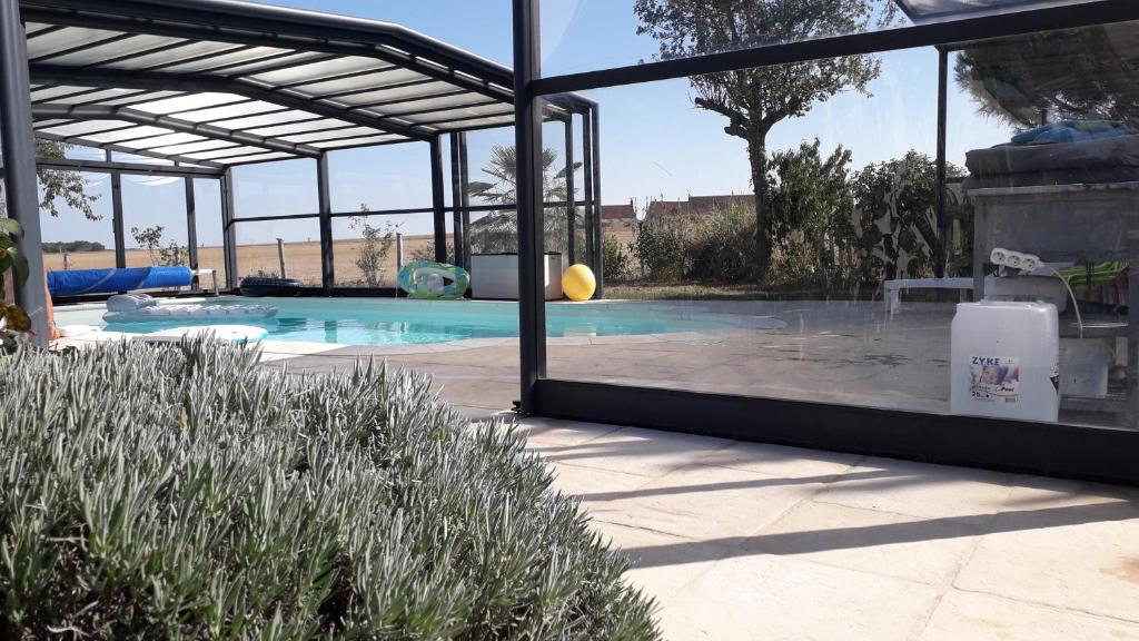 une piscine avec une grande fenêtre en verre dans l'établissement Au bout du monde 2 piscine et spa, à Les Hermites