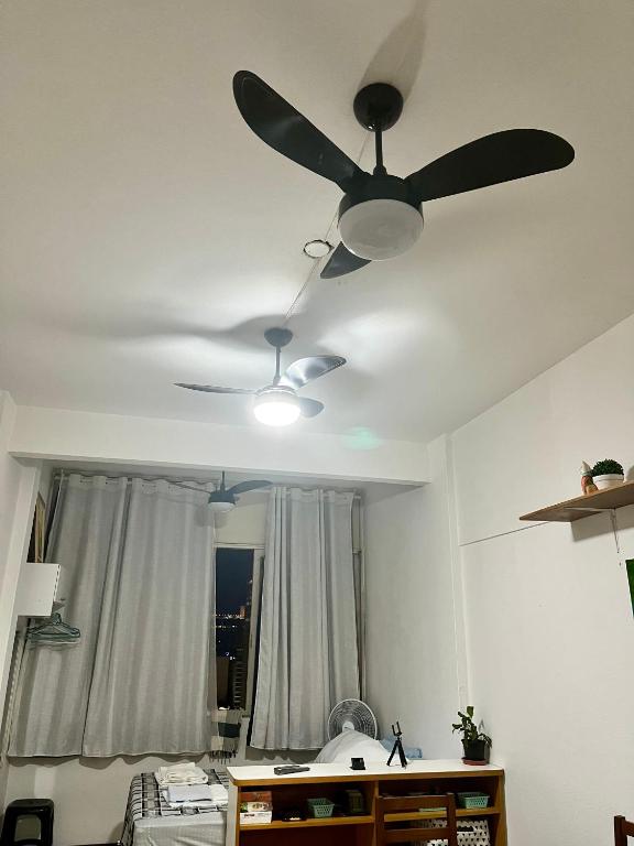 a ceiling fan in a room with a bedroom at Studio no Largo da Carioca - Rio de Janeiro in Rio de Janeiro