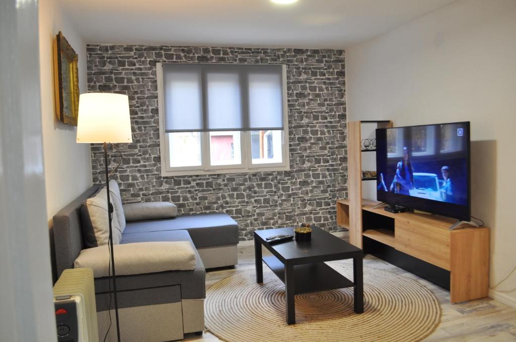 - un salon avec un canapé et une télévision dans l'établissement Apartman Kućica - Smederevo, à Smederevo