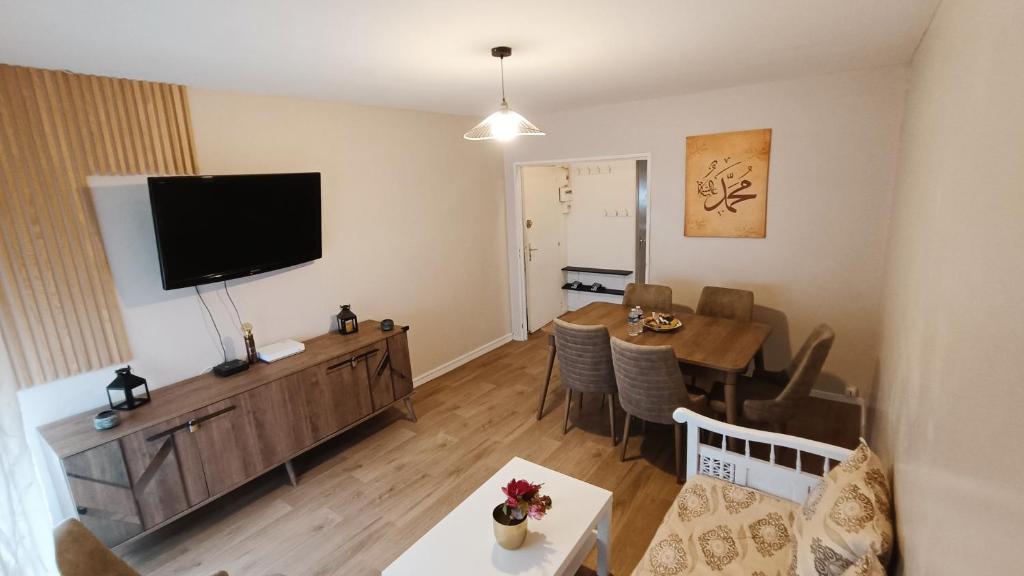 a living room with a dining table and a flat screen tv at Dijon Nobel in Dijon