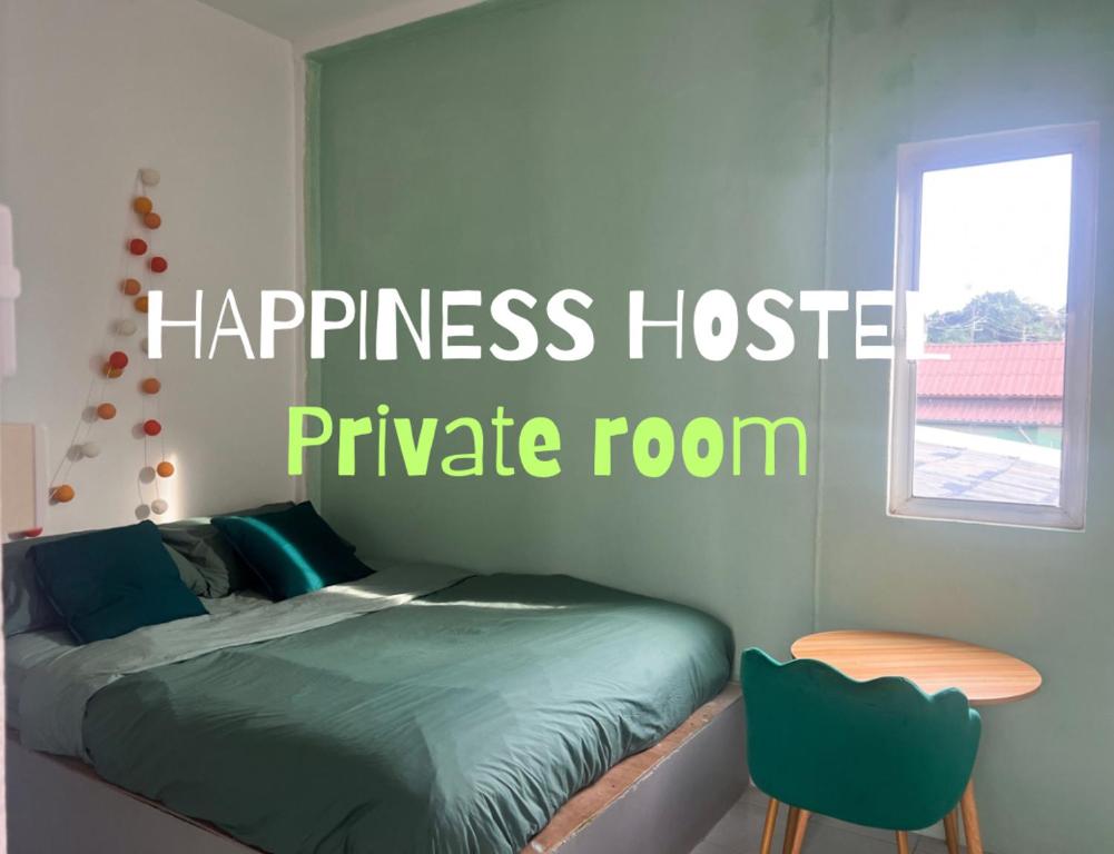 a bedroom with a bed and a table and a window at Happiness Hostel Private room in Phra Ae beach