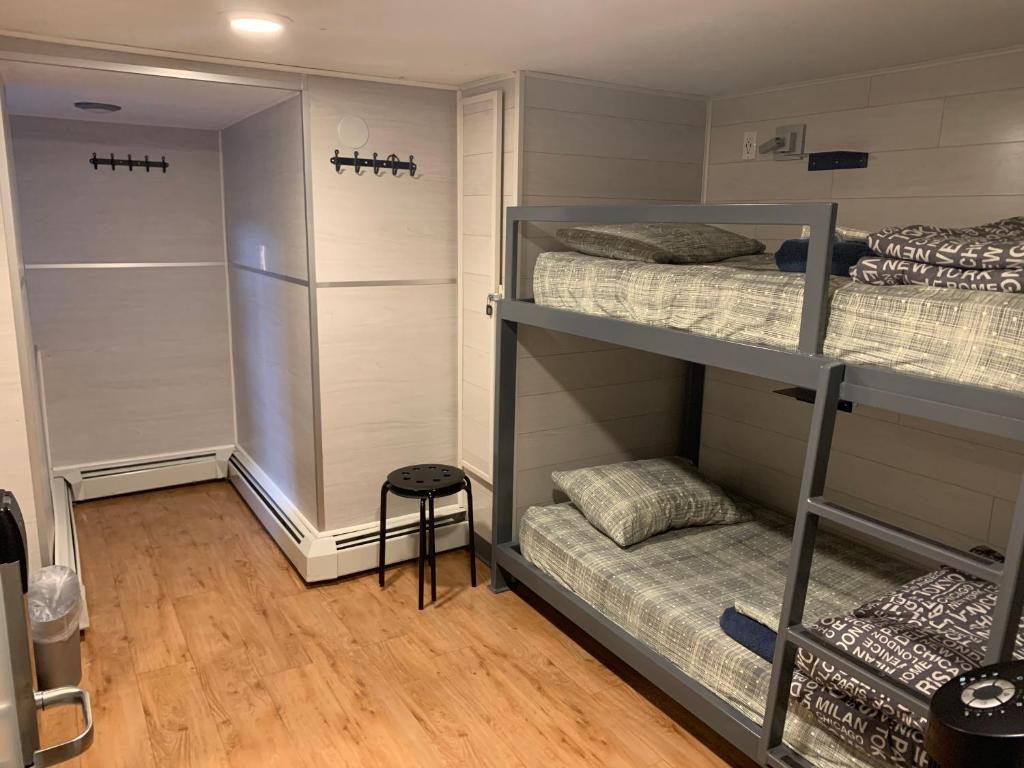 a room with two bunk beds and a stool at Jasper Downtown Hostel in Jasper