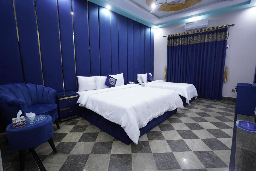 una camera d'albergo con due letti e una sedia di Karachi Guest House Johar a Karachi