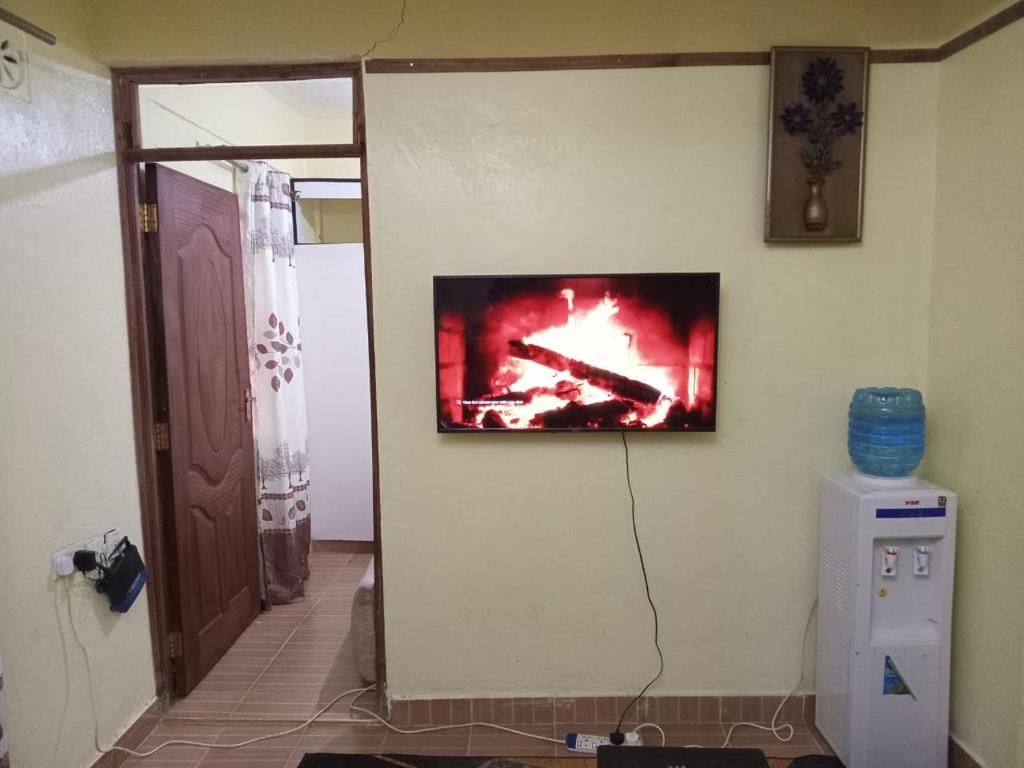 TV colgada en la pared de una habitación en Perpetual, en Nairobi