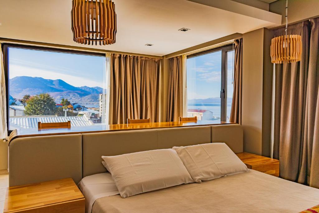 um quarto com uma cama em frente a uma grande janela em Miralejos em Ushuaia