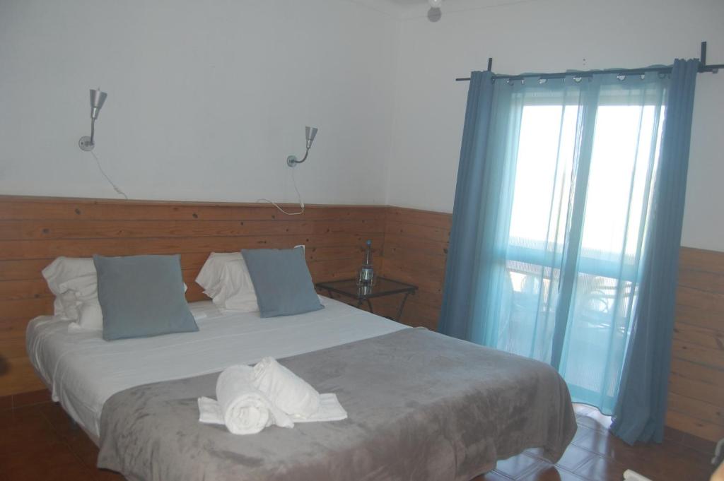 a bedroom with a bed with two towels on it at CASA DA HORTA in Aljezur