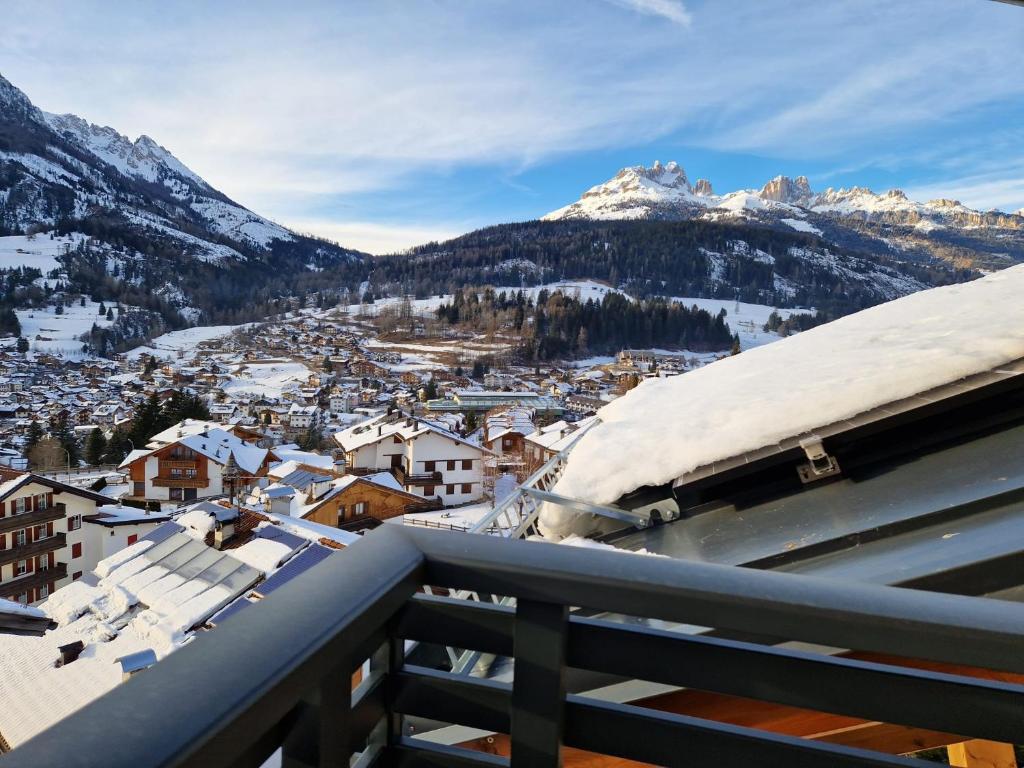 einen Blick vom Balkon einer Stadt mit schneebedeckten Bergen in der Unterkunft Appartamento SOMEDA in Moena