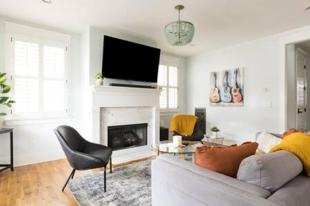 a living room with a couch and a fireplace at The Lillian House - Steps to Five Points in Nashville