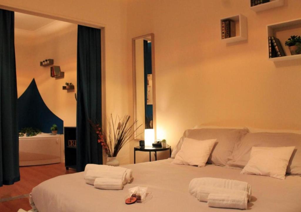 um quarto com uma cama branca e toalhas em Bracco Rooms & Suites em Matera