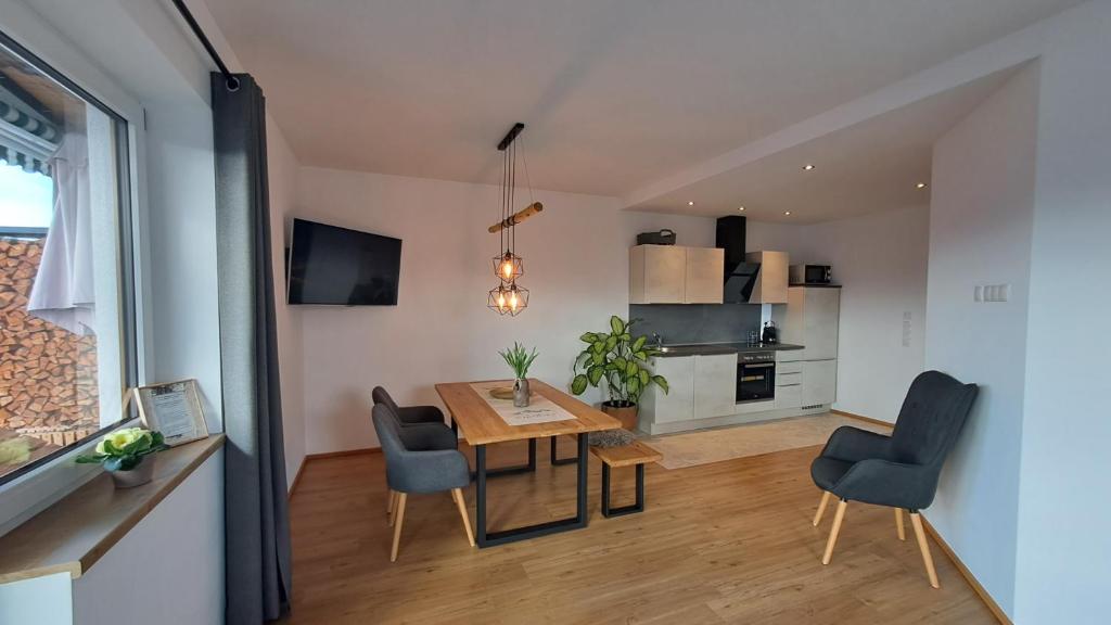 uma cozinha e sala de jantar com mesa e cadeiras em Panorama Appartements Filzerhof em Kirchberg in Tirol