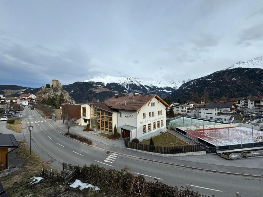 a city with a street and mountains in the background at Apart Weitblick in Ladis