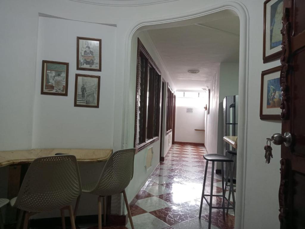 un pasillo con sillas y una mesa en una casa en ESTADIO APARTA HOTEL 201 en Medellín