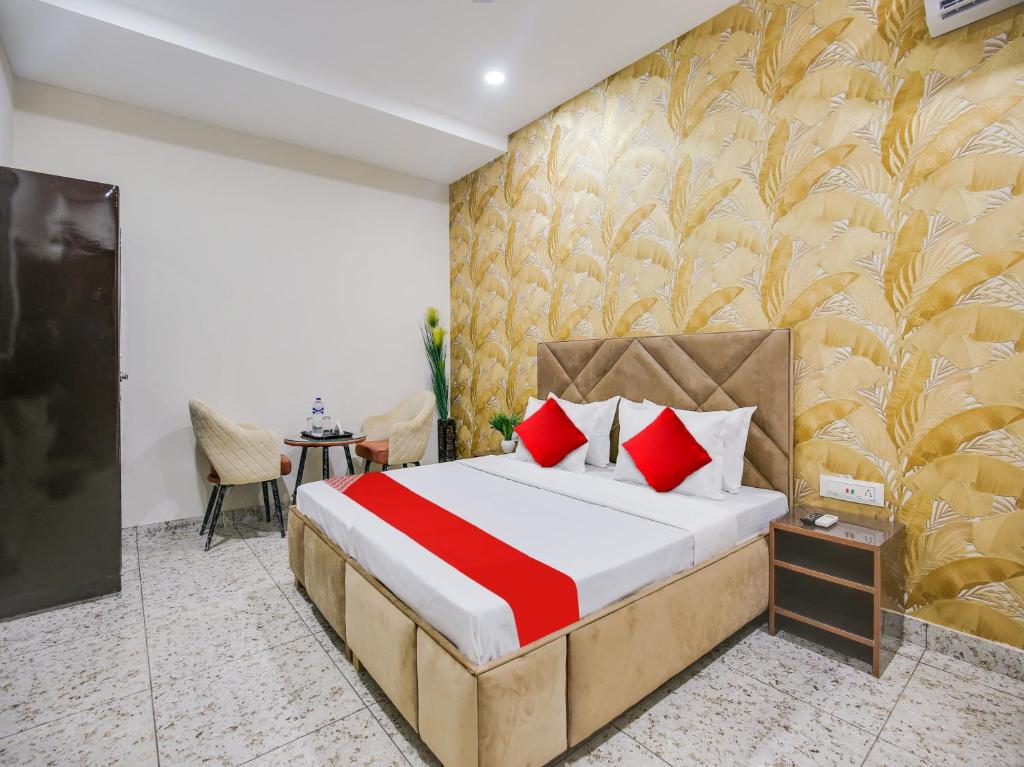 ein Hotelzimmer mit einem Bett mit roten Kissen in der Unterkunft Super OYO Silver Sky in Ludhiana